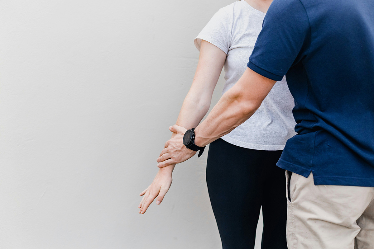 A physiotherapist working with a client. A physiotherapist working with a client.