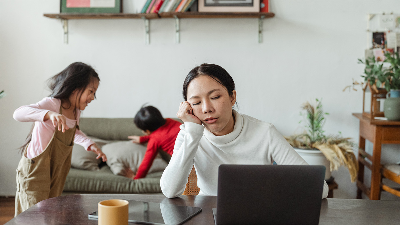 A woman looking tired at the computer.