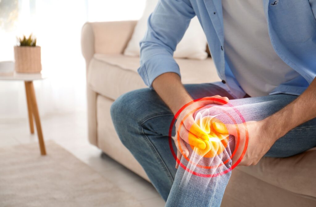 A person trying to soothe chronic knee pain with their hands.
