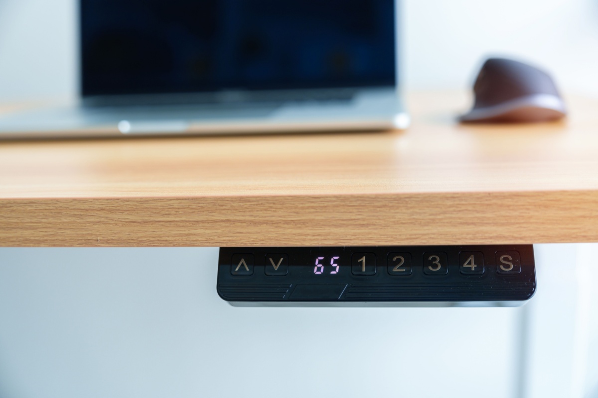 Close-up of electronic height adjustment buttons on a motorized standing desk.